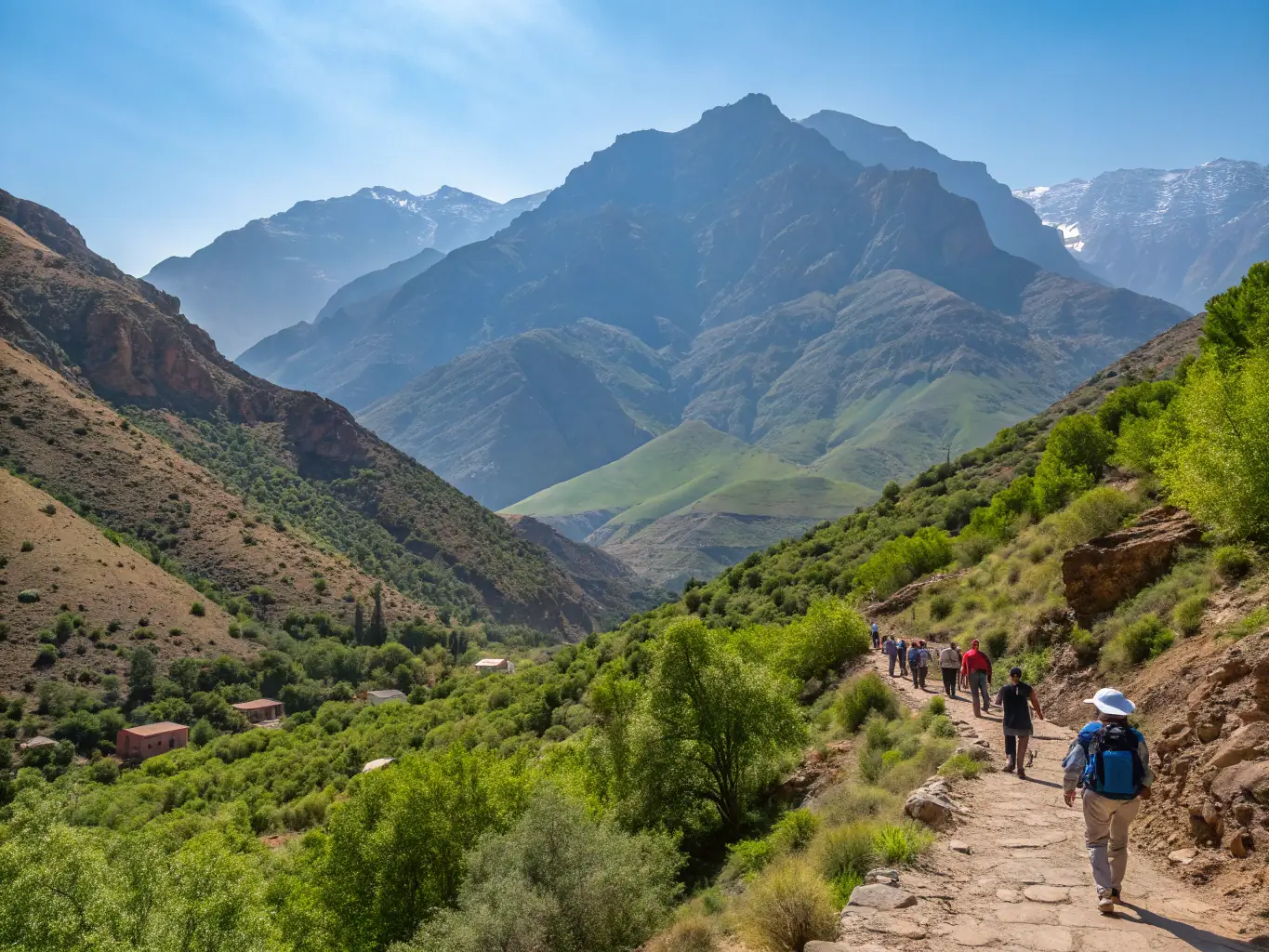 An exhilarating image of travelers hiking in the Atlas Mountains, surrounded by stunning mountain scenery and clear blue skies.
