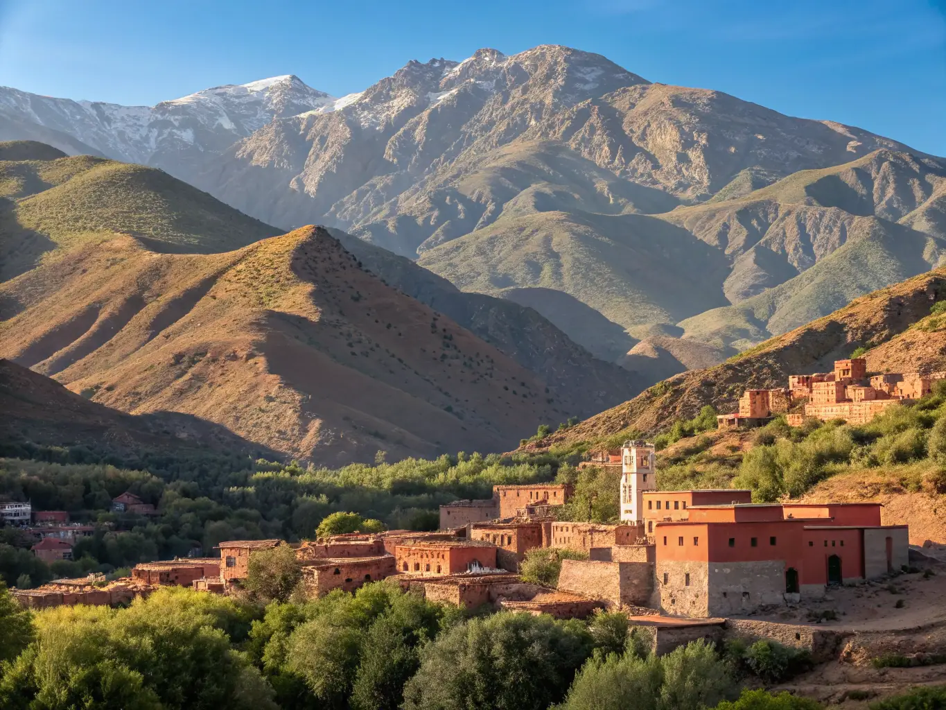 A breathtaking image of the Atlas Mountains, with snow-capped peaks and lush green valleys.